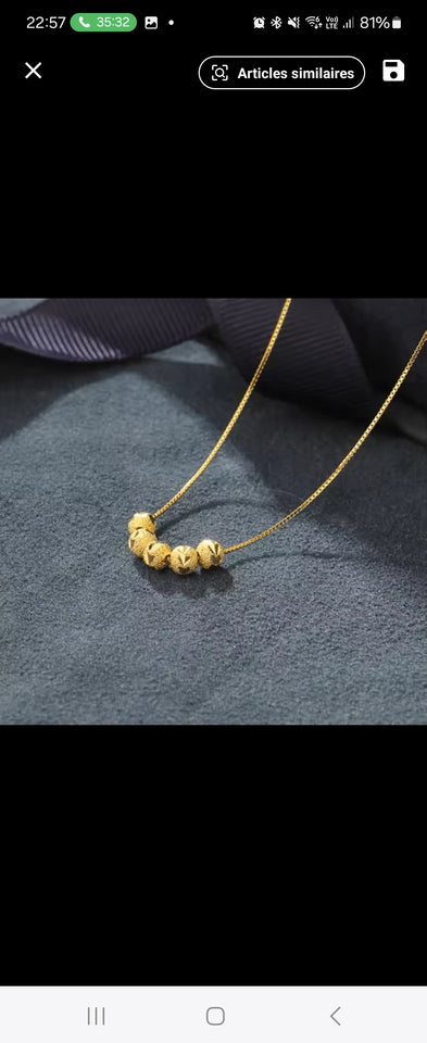Collier en acier inoxydable doré, orné de cinq perles finement texturées. Un bijou délicat et lumineux, facile à porter au quotidien.