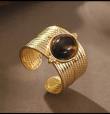 Bague en acier inoxydable doré, ornée d'une pierre effet œil de tigre. Réglable, résistante à l’eau et intemporelle