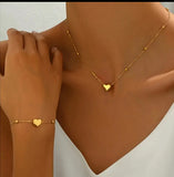 Ensemble collier et bracelet en acier inoxydable doré, orné de délicats pendentifs en forme de cœur. Sa chaîne fine et élégante, rehaussée de petites perles dorées, apporte une touche de féminité et de raffinement.