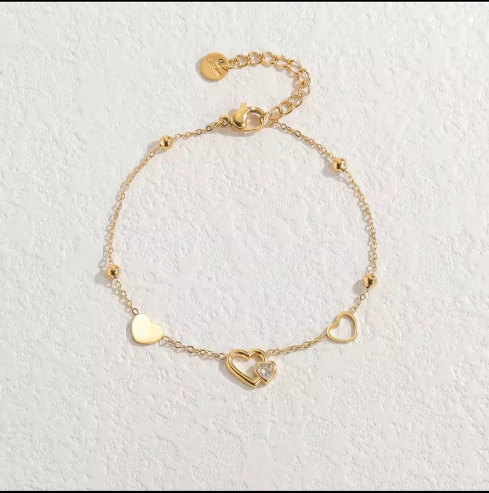 Un nouveau bracelet élégant en acier inoxydable au toucher luxueux, orné de motifs papillon, cœur, couronne et trèfle. Cette pièce unique et tendance constitue un cadeau idéal pour la famille, en particulier pour le Nouvel An.