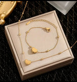 Ensemble collier et bracelet en acier inoxydable doré, orné de délicats pendentifs en forme de cœur. Sa chaîne fine et élégante, rehaussée de petites perles dorées, apporte une touche de féminité et de raffinement.