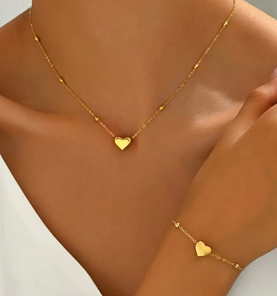Ensemble collier et bracelet en acier inoxydable doré, orné de délicats pendentifs en forme de cœur. Sa chaîne fine et élégante, rehaussée de petites perles dorées, apporte une touche de féminité et de raffinement.
