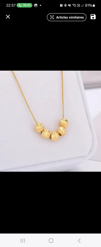 Collier en acier inoxydable doré, orné de cinq perles finement texturées. Un bijou délicat et lumineux, facile à porter au quotidien.
