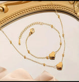 Ensemble collier et bracelet en acier inoxydable doré, orné de délicats pendentifs en forme de cœur. Sa chaîne fine et élégante, rehaussée de petites perles dorées, apporte une touche de féminité et de raffinement.